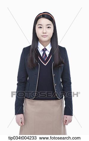 Stock Image - a female student with school uniform standing up straight. Fotosearch