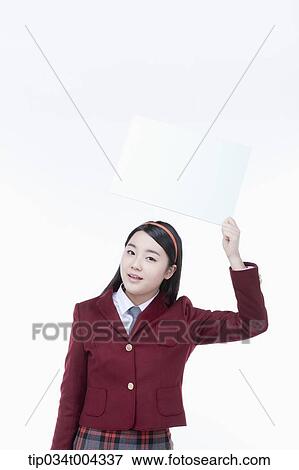 Stock Photo - a female student with school uniform holding an empty white paper over her head. Fotosearch