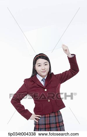 Stock Photo - a female student with school uniform holding an empty white paper over her head. Fotosearch