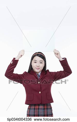 a female student with school uniform holding an empty white paper over her head View Large Photo Image Stock Photograph - a female student with school uniform holding an empty white paper over her head. Fotosearch
