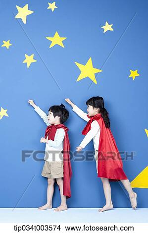 Picture - a girl and a boy posing like a superman in their side ways. Fotosearch
