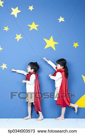 Stock Image - a girl and a boy posing like a superman in their side ways. Fotosearch