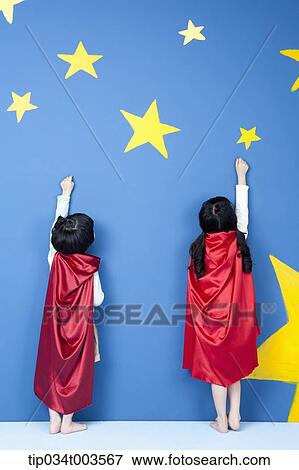 a girl and a boy posing like a superman in their backs while wearing red capes View Large Photo Image Stock Photo - a girl and a boy posing like a superman in their backs while wearing red capes. Fotosearch