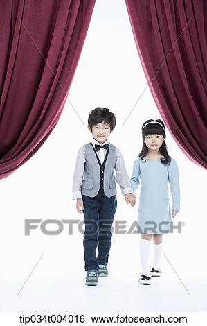 Stock Photograph - a girl and a boy walking out on stage hand in hand . Fotosearch