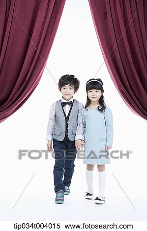Stock Photography - a girl and a boy walking out on stage hand in hand . Fotosearch