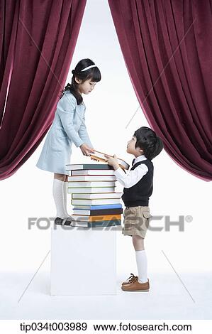 a girl granting a book to a boy under a stage View Large Photo Image Stock Photo - a girl granting a book to a boy under a stage. Fotosearch