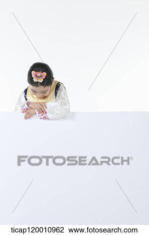 Stock Image - a girl in Hanbok holding an empty whiteboard. Fotosearch