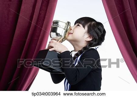 a girl kissing her trophy cup in front of red curtains View Large Photo Image Picture - a girl kissing her trophy cup in front of red curtains. Fotosearch