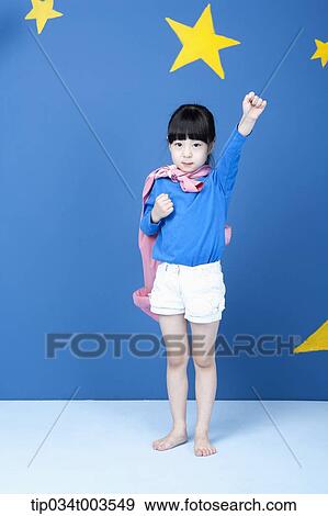 Stock Photo - a girl posing like a superwoman with a pink cape. Fotosearch