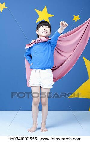 Stock Photography - a girl posing like a superwoman with a pink cape around her neck. Fotosearch
