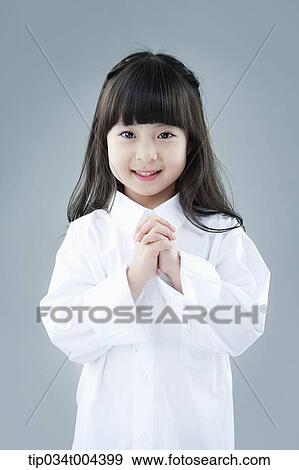 A Girl Posing While Holding Two Hands Together Stock Photo Tip034t Fotosearch