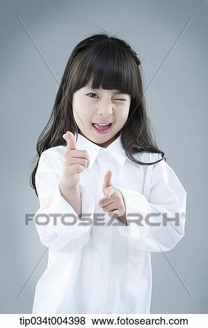 Stock Photo - a girl posing while winking . Fotosearch