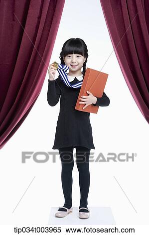 Stock Photography - a girl wearing a medal holding a book in her arm . Fotosearch