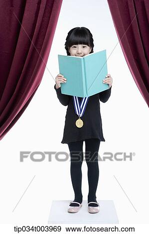 Stock Photo - a girl wearing a medal reading on a stage . Fotosearch