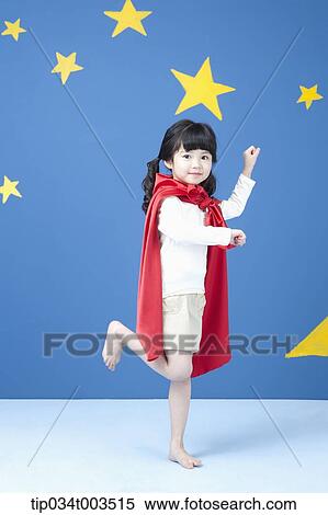 Stock Photography - a girl wearing a superman cape posing like a superman in blue background with stars. Fotosearch