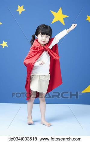 Stock Photo - a girl wearing a superman cape spreading her arm like a superman in blue background with stars. Fotosearch