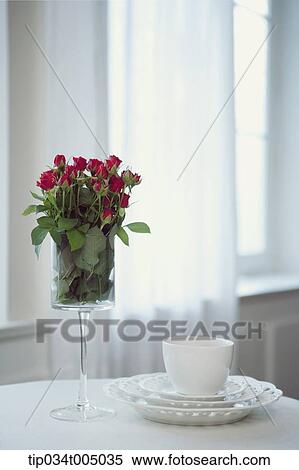 a glass jar with flowers and a cup of coffee on a table View Large Photo Image Stock Photography - a glass jar with flowers and a cup of coffee on a table. Fotosearch