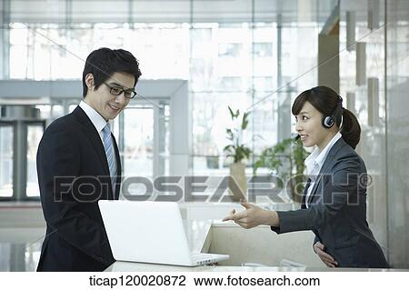 a help desk woman explaining to businessman through laptop View Large Photo Image Stock Image - a help desk woman explaining to businessman through laptop. Fotosearch