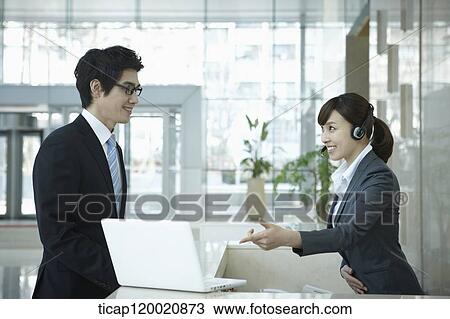 a help desk woman explaining to businessman through laptop View Large Photo Image Stock Image - a help desk woman explaining to businessman through laptop. Fotosearch