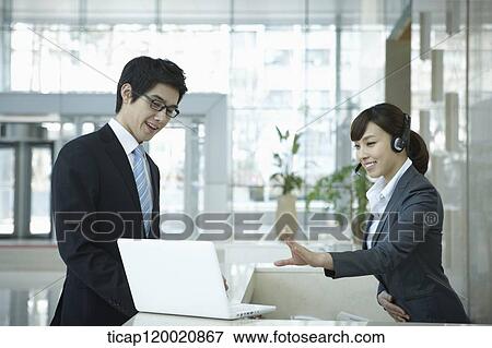 a help desk woman explaining to businessman through laptop View Large Photo Image Stock Photo - a help desk woman explaining to businessman through laptop. Fotosearch