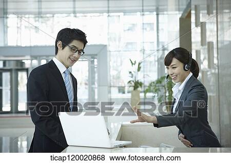 a help desk woman explaining to businessman through laptop View Large Photo Image Stock Photo - a help desk woman explaining to businessman through laptop. Fotosearch