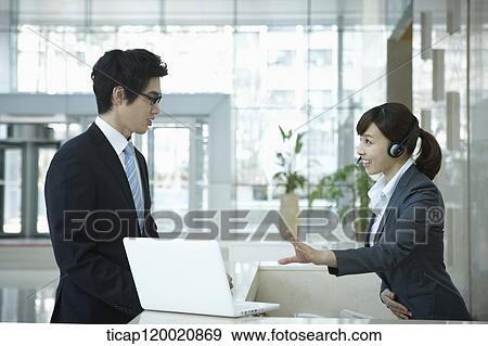 a help desk woman explaining to businessman through laptop View Large Photo Image Stock Photo - a help desk woman explaining to businessman through laptop. Fotosearch
