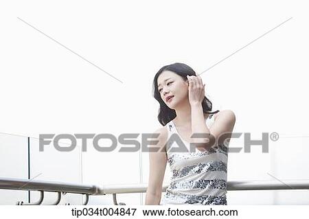 Stock Photo - a lady in silver-white striped sleeveless shirt posing . Fotosearch