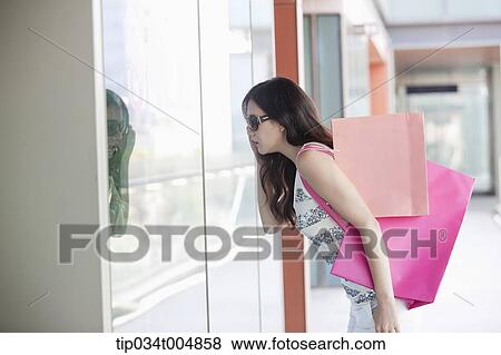 a lady with sunglasses and shopping bags looking on a show window View Large Photo Image Stock Photo - a lady with sunglasses and shopping bags looking on a show window. Fotosearch
