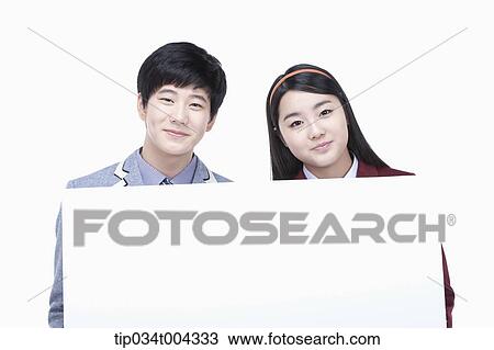 a male and female students with school uniform holding an empty paper View Large Photo Image Stock Image - a male and female students with school uniform holding an empty paper . Fotosearch