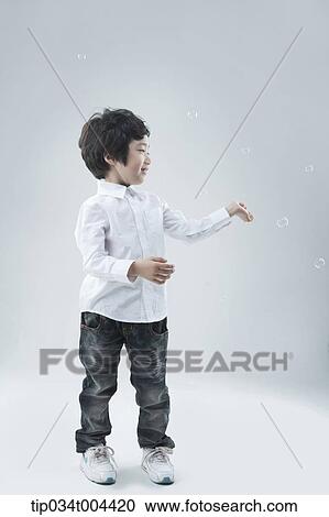 a male kid playing with bubbles View Large Photo Image Stock Image - a male kid playing with bubbles. Fotosearch
