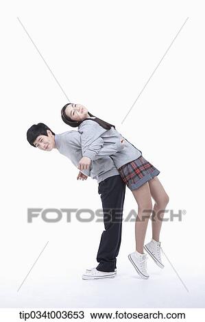 Stock Image - a male student carrying female student on his back. Fotosearch