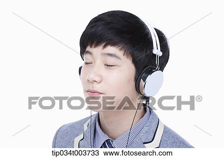 a male student listening on a headphone View Large Photo Image Stock Image - a male student listening on a headphone. Fotosearch