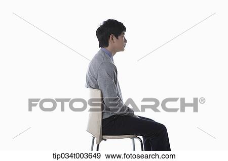 a male student sitting on a chair facing side way View Large Photo Image Stock Photo - a male student sitting on a chair facing side way. Fotosearch