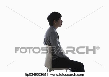a male student sitting on a chair under a dark shadow View Large Photo Image Stock Image - a male student sitting on a chair under a dark shadow. Fotosearch