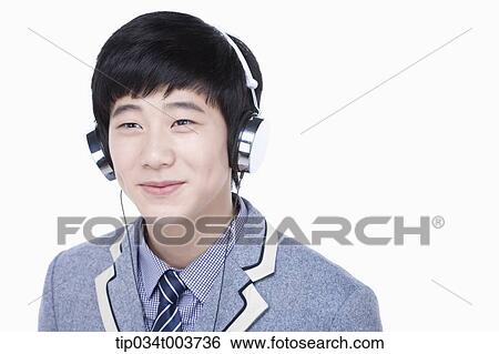 a male student smiling while listening on a headphone View Large Photo Image Stock Photograph - a male student smiling while listening on a headphone. Fotosearch