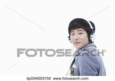 Stock Image - a male student wearing a headphone facing camera. Fotosearch