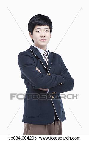 Stock Photography - a male student wearing school uniform standing with arms crossed . Fotosearch
