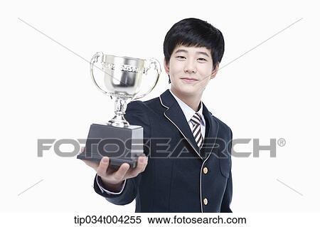 a male student wearing school uniform holding a trophy cup View Large Photo Image Stock Photography - a male student wearing school uniform holding a trophy cup. Fotosearch