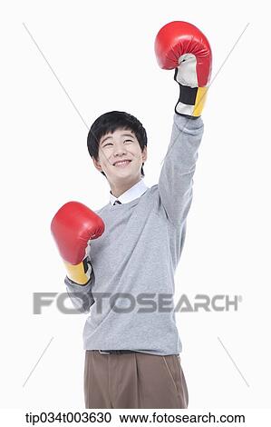 a male student with boxing gloves raising his arm up View Large Photo Image Stock Image - a male student with boxing gloves raising his arm up. Fotosearch