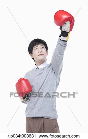 a male student with boxing gloves raising his arm up View Large Photo Image Stock Image - a male student with boxing gloves raising his arm up. Fotosearch