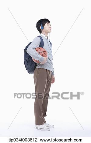 a male student with headphones holding a basketball in his arm View Large Photo Image Stock Image - a male student with headphones holding a basketball in his arm. Fotosearch