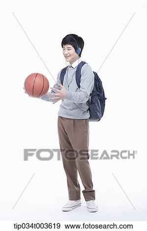 Stock Photo - a male student with headphones playing with a basketball . Fotosearch