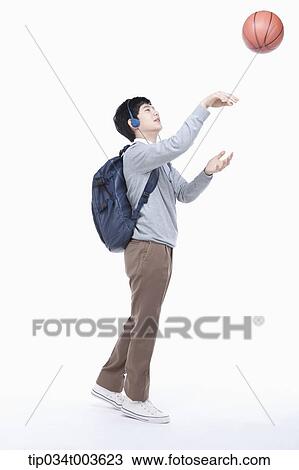 a male student with headphones shooting a basketball in the air View Large Photo Image Stock Image - a male student with headphones shooting a basketball in the air. Fotosearch