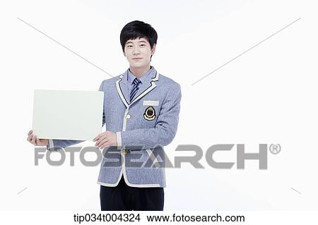 Picture - a male student with school uniform holding an empty white paper . Fotosearch