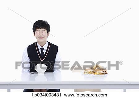 a male student with school uniform sitting on a chair with a rice in front of him View Large Photo Image Stock Image - a male student with school uniform sitting on a chair with a rice in front of him . Fotosearch