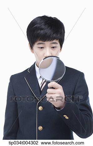 a male student with school uniform looking through a magnifying glass View Large Photo Image Stock Image - a male student with school uniform looking through a magnifying glass. Fotosearch