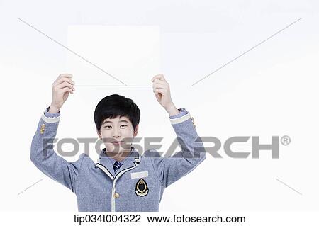 a male student with school uniform holding an empty white paper over his head View Large Photo Image Stock Image - a male student with school uniform holding an empty white paper over his head. Fotosearch