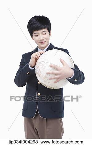 a male student with school uniform looking at a globe View Large Photo Image Stock Photo - a male student with school uniform looking at a globe. Fotosearch