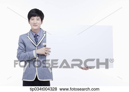 Stock Photo - a male student with school uniform holding a big empty white paper . Fotosearch