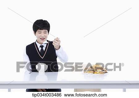 a male student with school uniform eating rice View Large Photo Image Stock Photograph - a male student with school uniform eating rice . Fotosearch